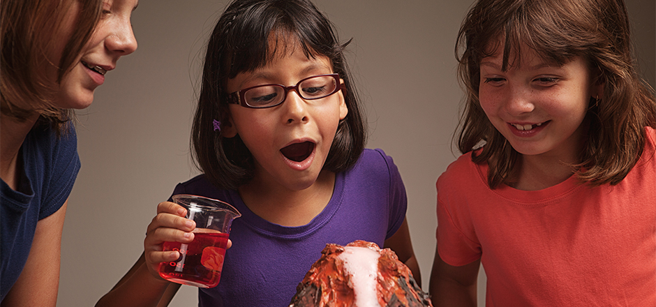 three young girls demonstrating a volcano science experiment