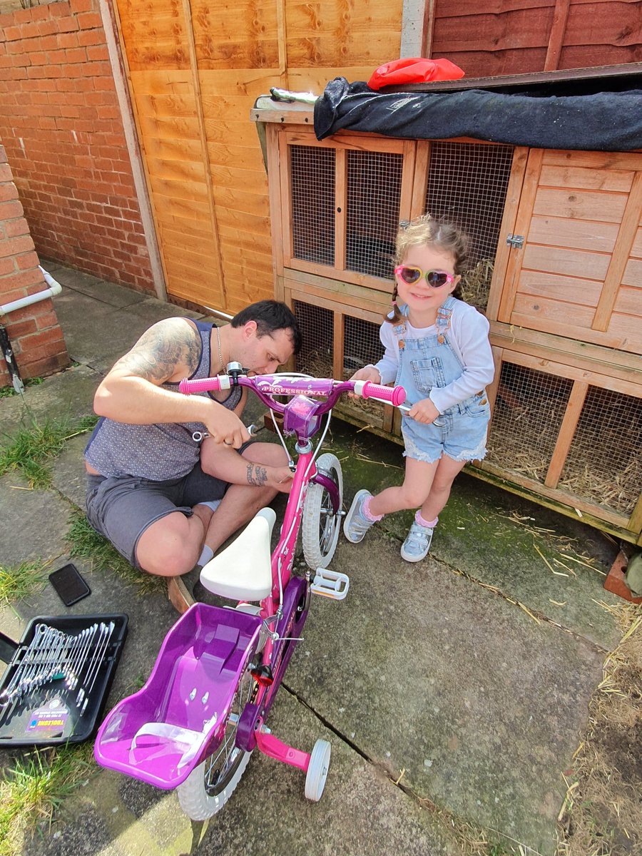 Helping daddy fix her bike
