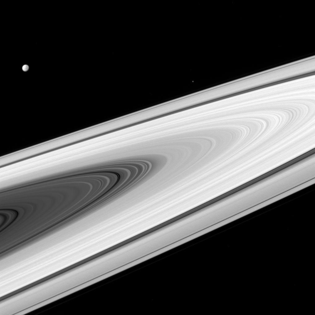 While the star of this photo is Saturn's trademark rings, you can also see its moons Dione (brightly in the upper left) and Epimetheus (very faintly on the right). This photo was taken by the Cassini spacecraft in 2016:  https://s.si.edu/34ka8dG 