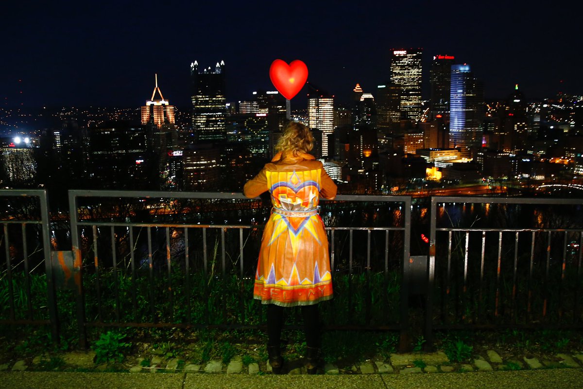 PGHCityPaper's tweet photo. Jena-Anne Sabom, an organizer of #LovefromPgh, stands atop Mount Washington with a lighted heart and decorated jacket following a moment in honor of essential workers amidst COVID-19. 

📸: @WickPhoto https://t.co/FjDXqQGnGv