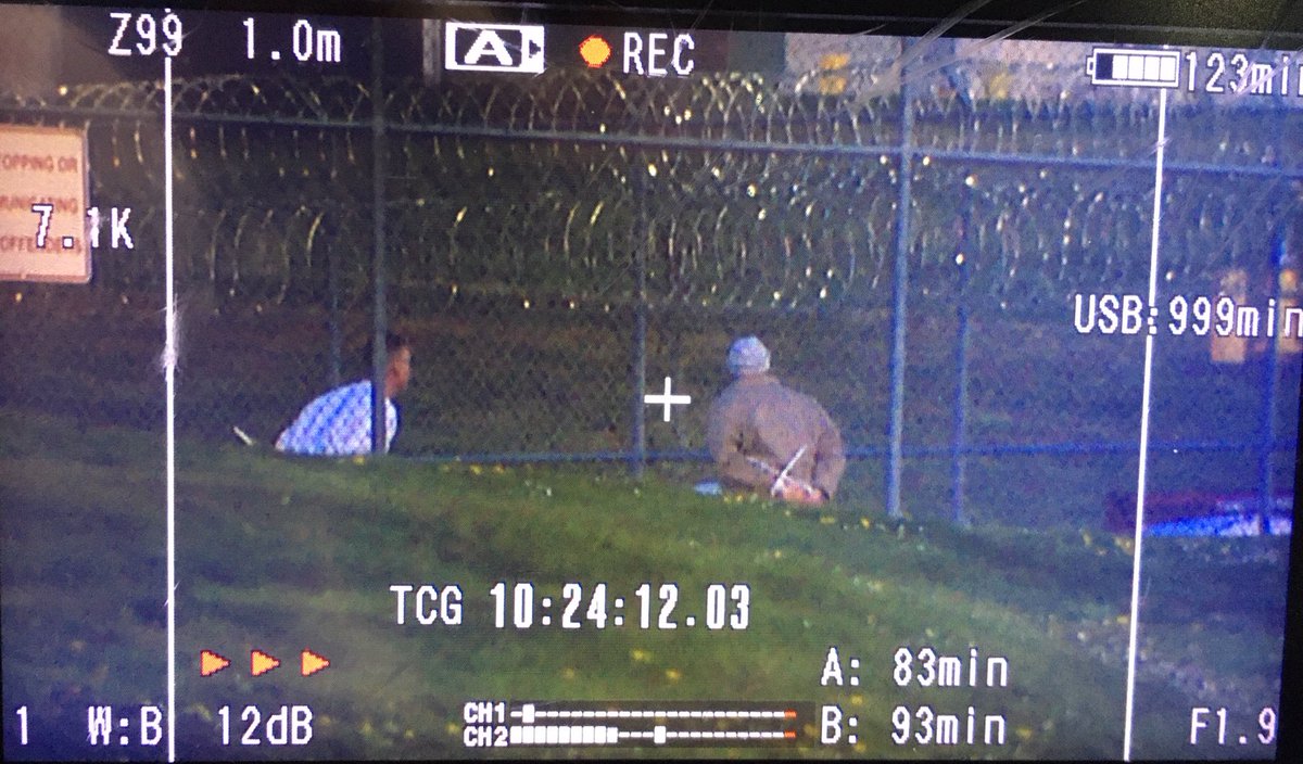 From our photographer on-scene, two inmates sit outside with zip tie-restraints. From our helicopter’s perspective, there are dozens of other inmates sitting outside in handcuffs like these two with officers nearby  #KOMONews