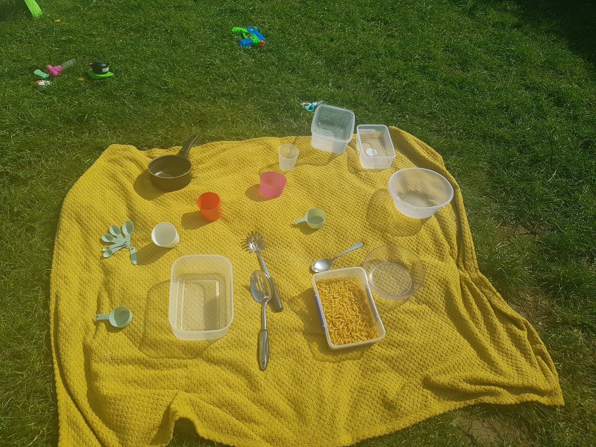 ManagerDarwins's tweet photo. One of our favourite sensory activities in the sunshine. Exploring pasta through filling and emptying different containers using household utensils. This will develop early maths and physical skills while provoking imagination and links to experiences from home. https://t.co/Mo0VsjRkG2