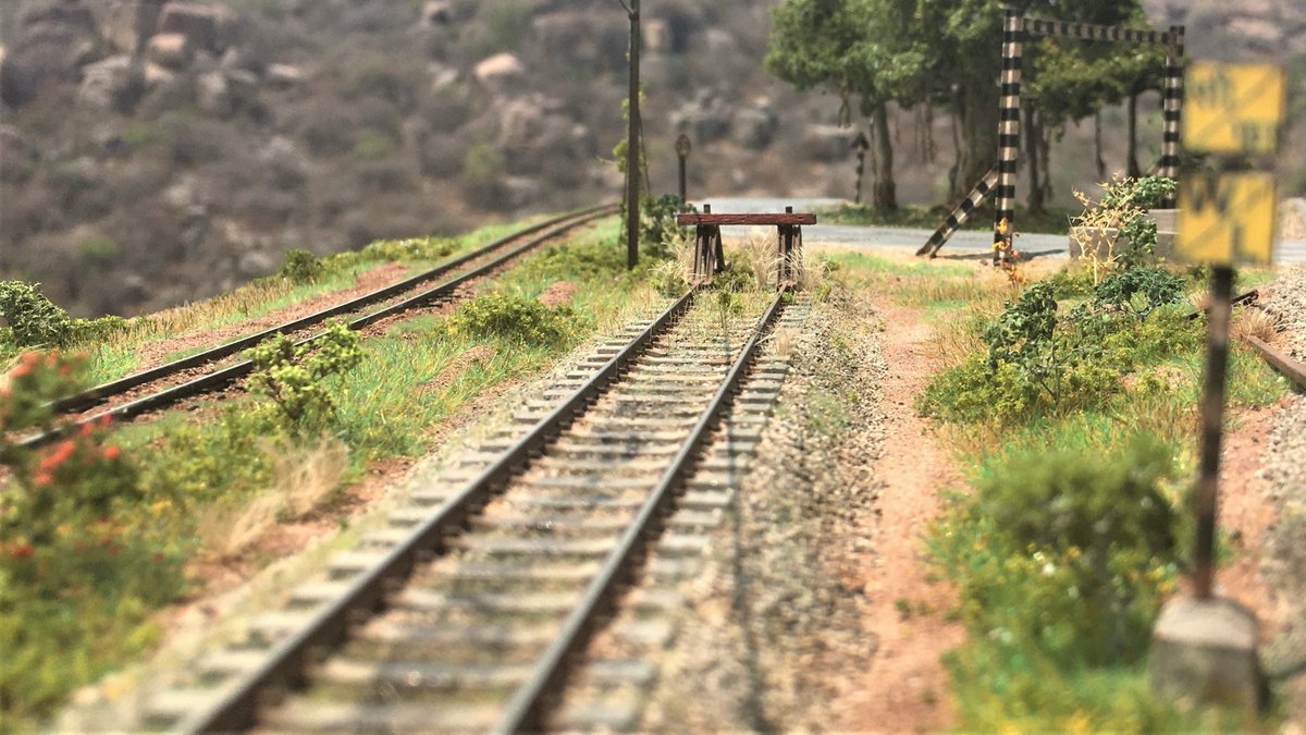 TDioramas's tweet photo. The siding. 
The buffer stop is scratchbuilt using Code 55 rails and stock HO scale 6X8 lumber. The growth is a mixture of statis grass, piece of jute hemp, and some foam foliage. https://t.co/rLbeba9YuX