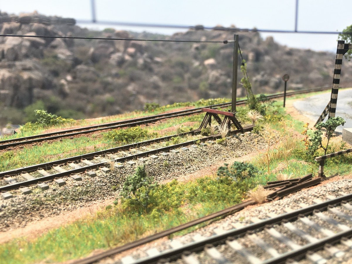 TDioramas's tweet photo. The siding. 
The buffer stop is scratchbuilt using Code 55 rails and stock HO scale 6X8 lumber. The growth is a mixture of statis grass, piece of jute hemp, and some foam foliage. https://t.co/rLbeba9YuX