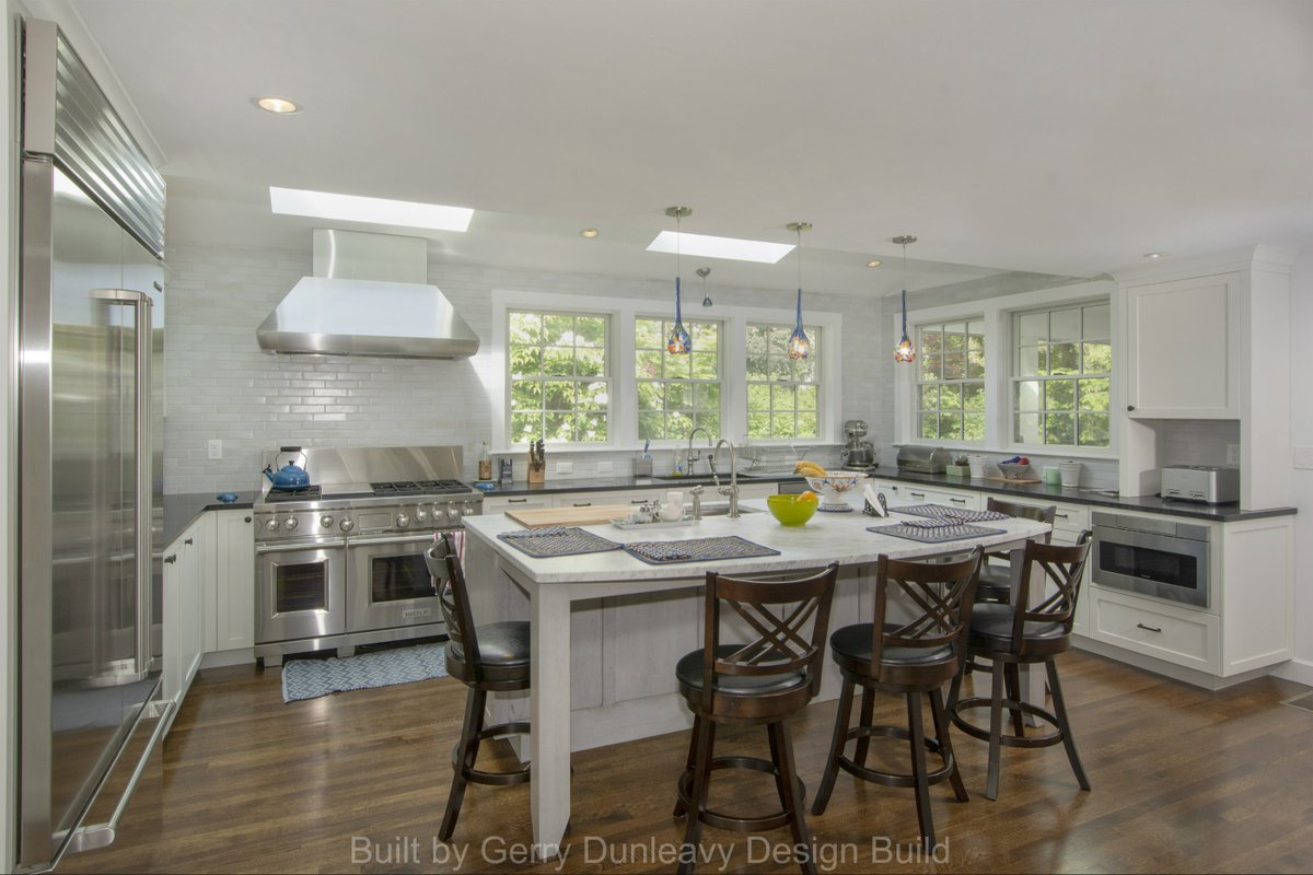 #Kitchen featuring custom cabinets, hood vent and skylights