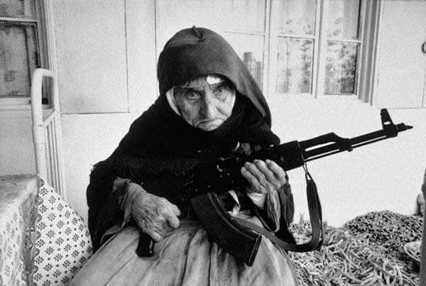 27 - Uma mulher armênia com 106 anos de idade protegendo a sua casa com uma arma automática.