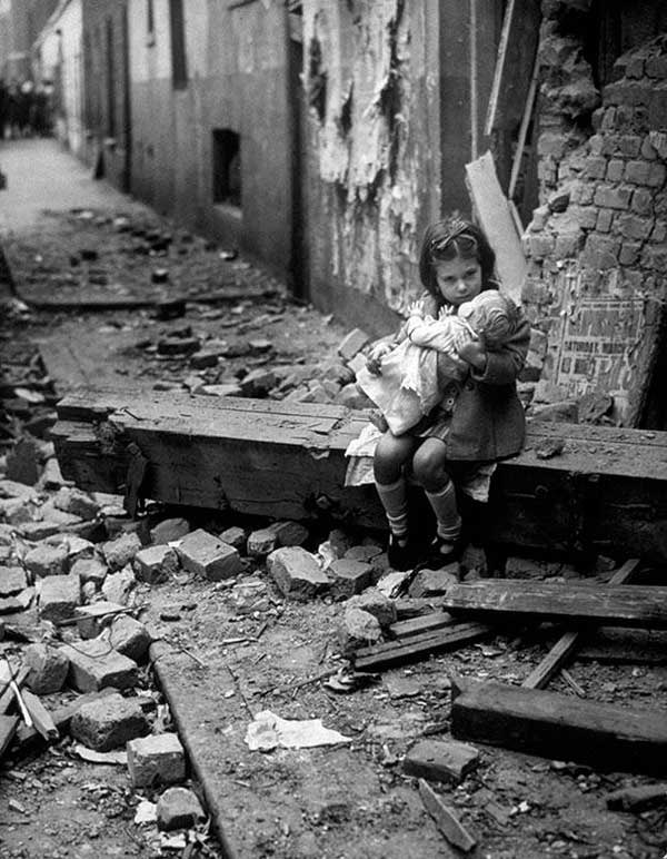 40 - Uma Menina sentada em frente a sua casa destruída em Londres na Segunda Guerra Mundial.