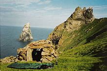 So, in the autumn of 1727 when the population would have been roughly 120 a group of 3 men and 8 boys were rowed out to Stac-an-Armin for what was meant to be a 2 week hunt during which they lived in a tiny bothy on the stac. The bothy and boat landing would have looked like this