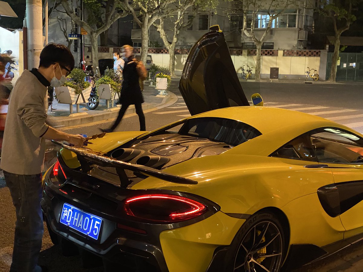 apgalbraith's tweet photo. You know Shanghai is getting back to normal when you see a guy roasting 羊肉串 over the exhaust pipes of a McLaren https://t.co/jJNI7n7GXl