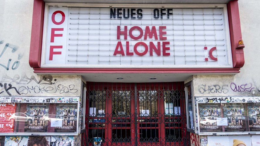 The Neues Off movie theater with its Marquee banner reading "Home Alone" and a sad smiley face in Berlin, Germany on March 18 2020  http://thr.cm/Y8e2g1m 