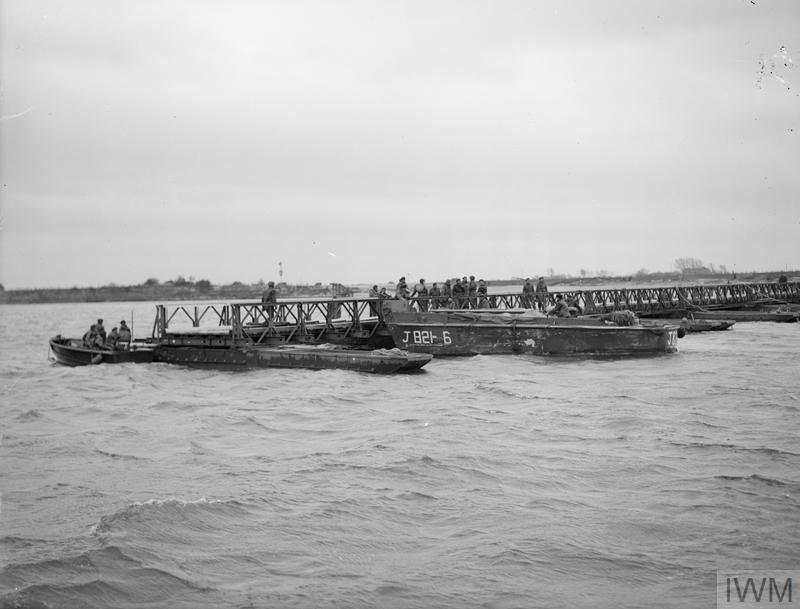 As soon as the crossing of the Ijssel was made, more landing craft sprang into action, transporting prefabricated sections of Bailey Bridge towards the crossing site. 12 hours after the assault began, the bridge was complete and armour was crossing the river. IWM A28059. 6/10
