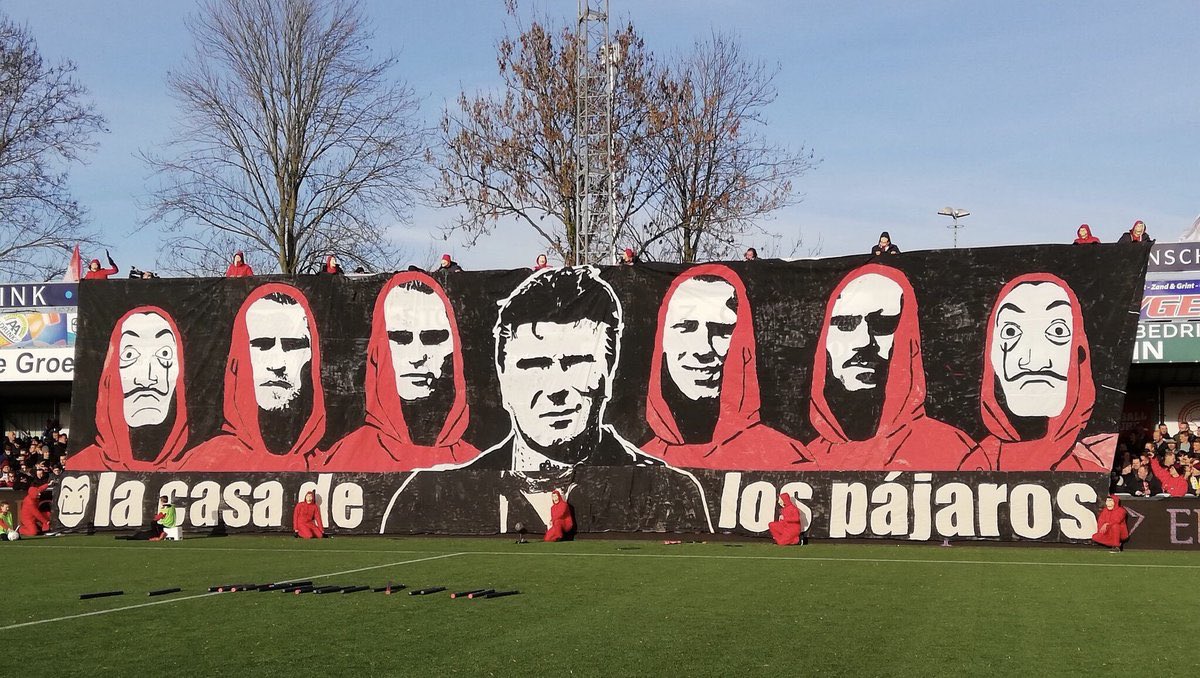 3. Januari 2019 - Penyokong dari kelab dari Divisyen 3 Belanda iaitu Ultras Ijselmeervogels menaikkan tifo yg memaparkan gambar manager dan pemain memakai kostum merah Money Heist.