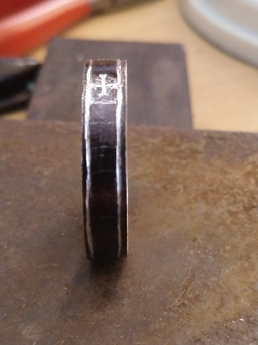 I engraved the first symbol so that I had a fixed point to work from, then used compasses to divide the ring into cells. The letter spacing isn't that simple, but the cells meant that I could spread them evenly around the ring. I used a bit of maths, but trial & error also works