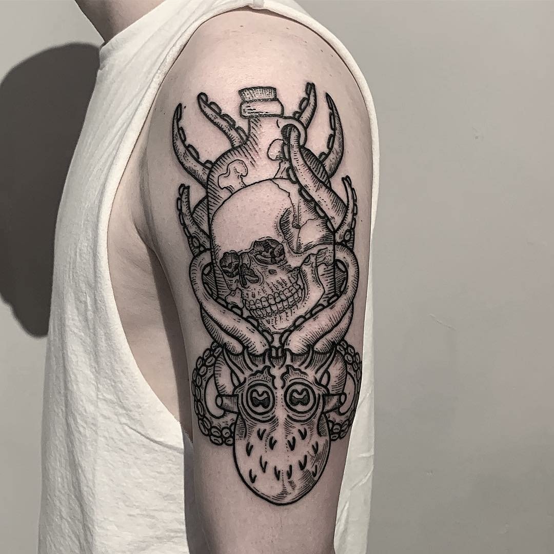 Octopus with a human skull tattoo on the tricep