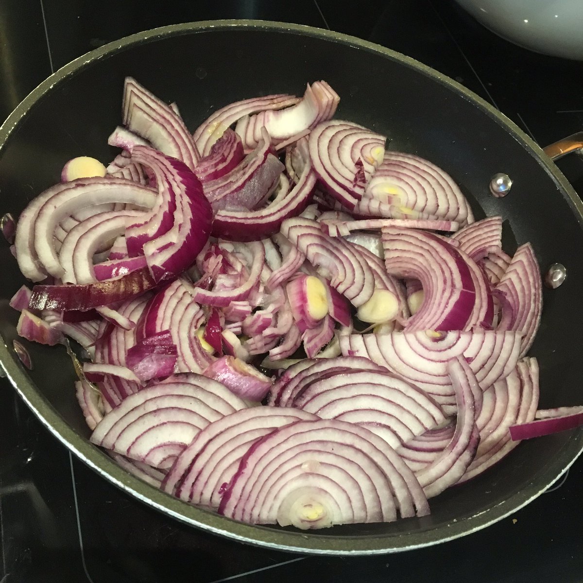 Now biryani is all about luxury so fry down your massive amounts of onion in massive amounts of ghee. You need this full pan of onions to sweat down like spinach. They need to be browned until they resemble Ken Dodds hair. This will take ages, which is good for that marinade.