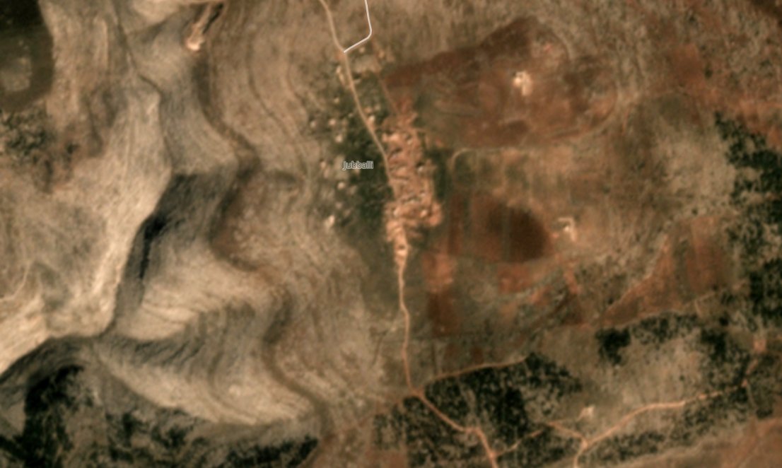 Google's satellite imagery isn't up to date enough to show the dirt berms that have gone up on the village's eastern and southern side (visible on Planet)