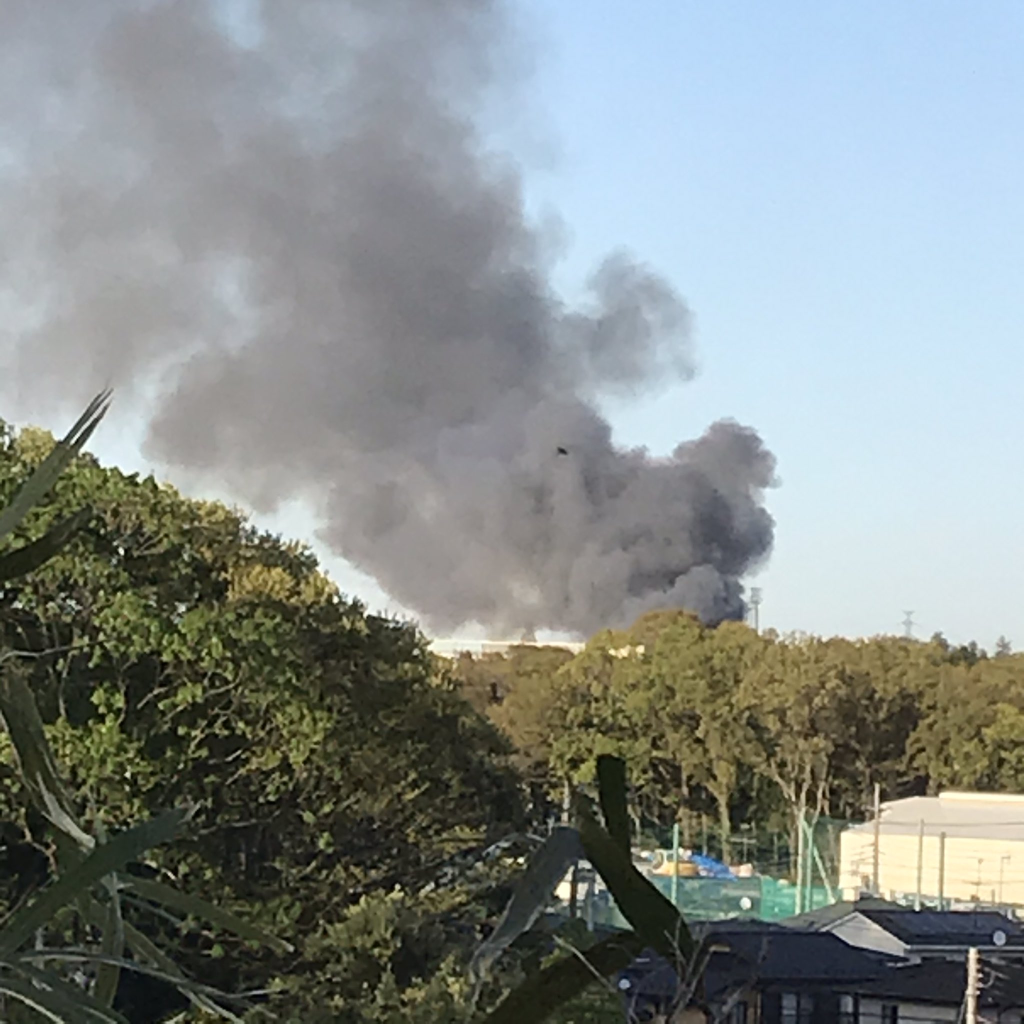 横浜市瀬谷区の資材置き場の火災現場から黒煙が立ち上っている画像