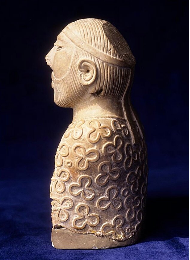 Fillet hairband with circular inlay ornament on forehead & similar such ornament on right upper arm. The two ends of fillet fall along the back & though the hair is carefully combed towards the back of the head. The sculpture stands 17.5 centimetres (6.9 inches) tall. (2/4)
