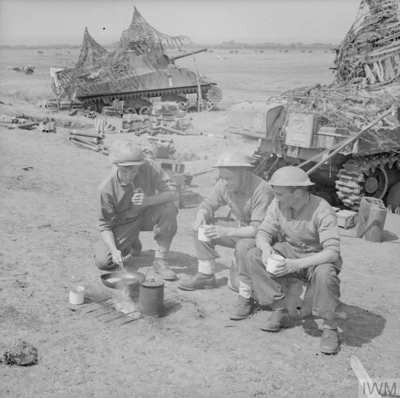 RTR troops in Italy, May 1944 cooking. Tea already done. Looks like fried eggs. Note Benghazhi burner 'dug in' and a griddle (non-issue). Nonchalent pipe smoking cook a bonus.