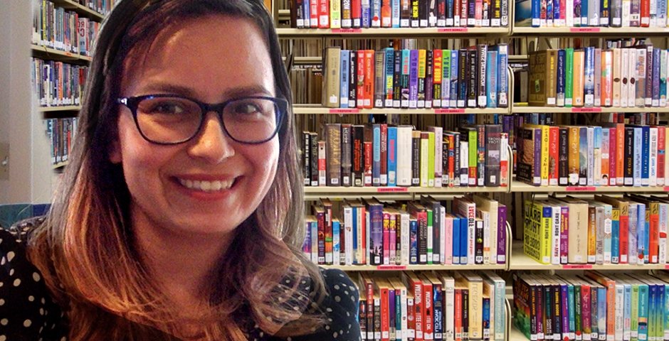 woman standing in front of bookshelves