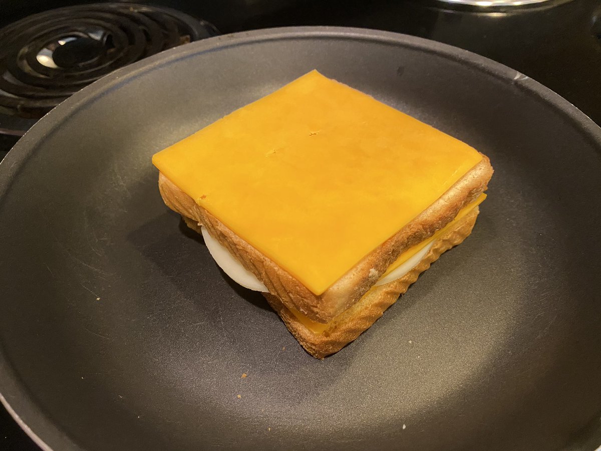 Throw bread, middle cheese and top cheese in pan. Throw EXTRA cheese slice on that shit.