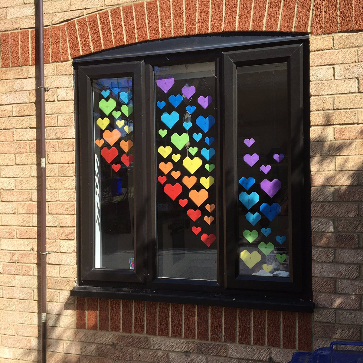 5) Finally, put up your display! I used a glue gun to stick my hearts up, but glue stick or sticky tape will work too. Have fun and do post pics of your rainbow heart windows! 