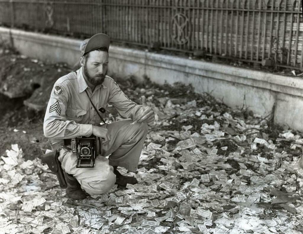 Histolines_'s tweet photo. American service photographer Frank Bond examines now-worthless Japanese Occupation currency littering the streets of Rangoon, May 1945 [1296x1000] via /r/HistoryPorn https://t.co/qEJipHdK2N https://t.co/rp3Ehy8pru https://t.co/klTL9yLorV