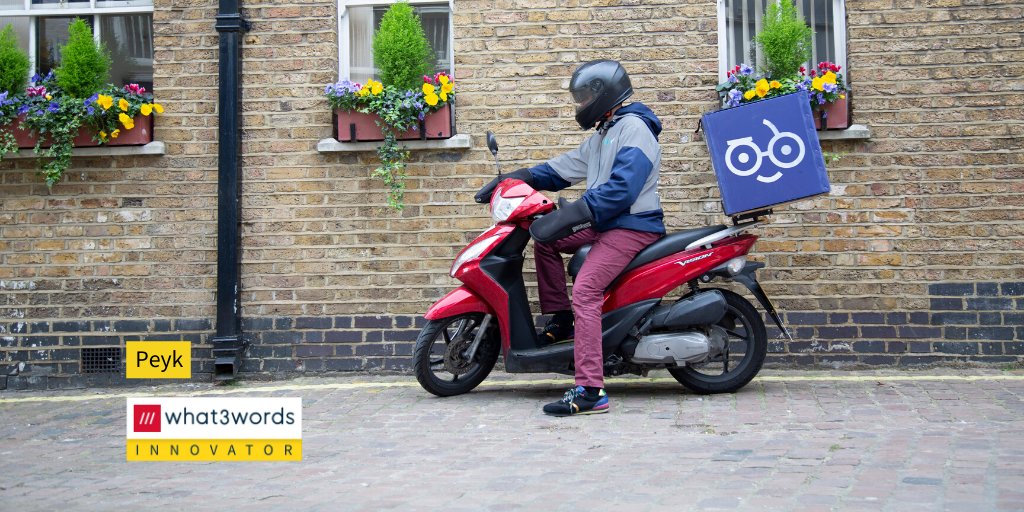 Peyk courier rides motorcycle on residential street.
