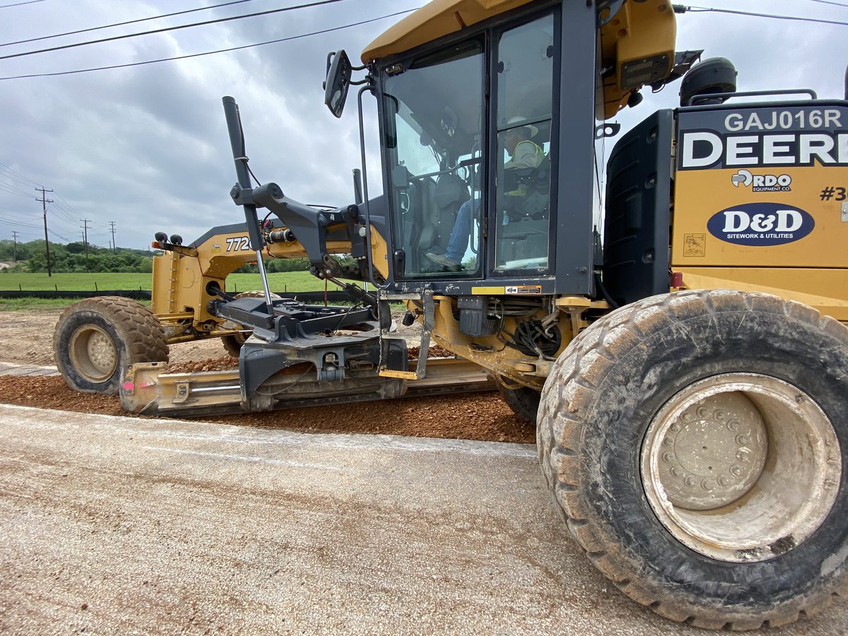 Our blade man demonstrates his talents and many years of experience by mixing the base on the asphalt and then evenly distributing the material across the narrowly excavated section on this portion of this large street reconstruction process.