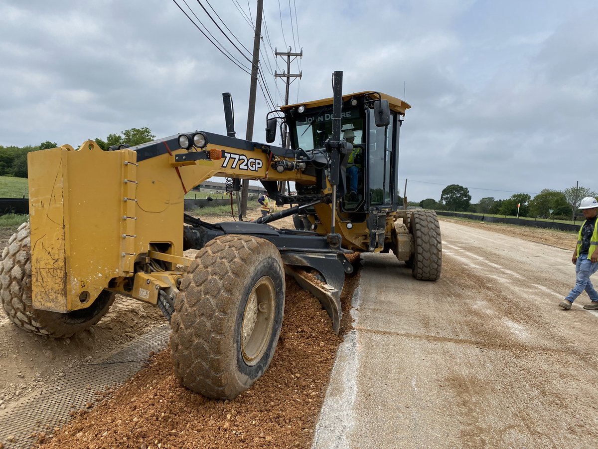 Our blade man demonstrates his talents and many years of experience by mixing the base on the asphalt and then evenly distributing the material across the narrowly excavated section on this portion of this large street reconstruction process.