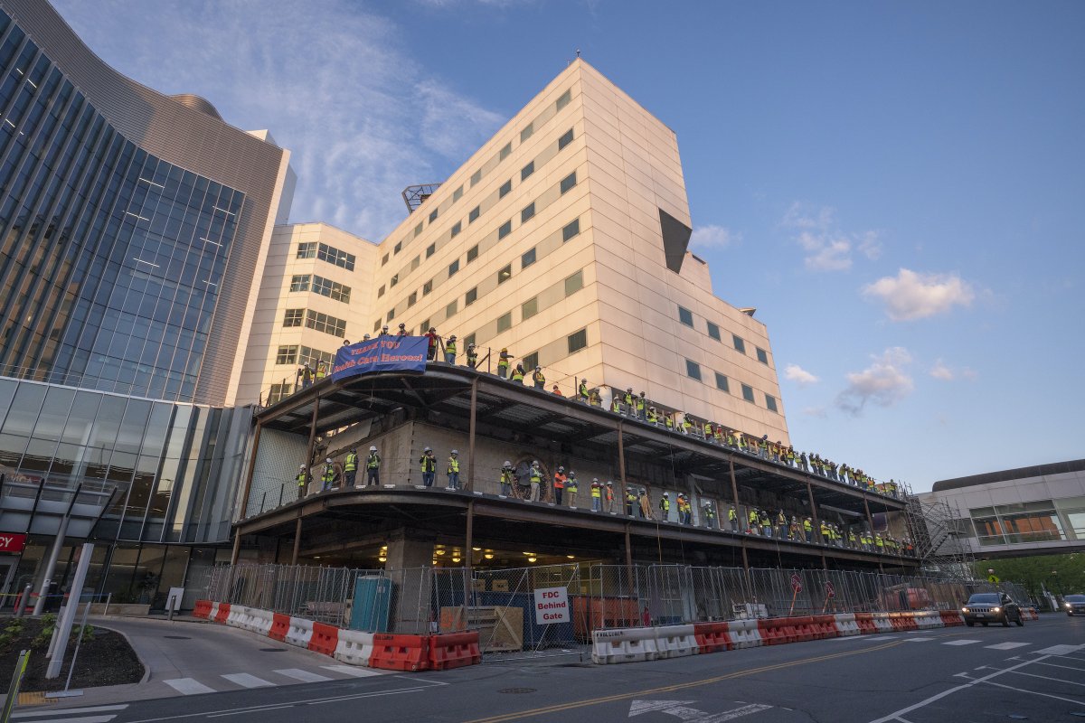 UVA's tweet photo. At 6:30 a.m. this morning, construction crews working on the new @uvahealthnews wing lined up to applaud and cheer health care workers on their way into work or leaving their shifts. https://t.co/YoghO0xnk4
