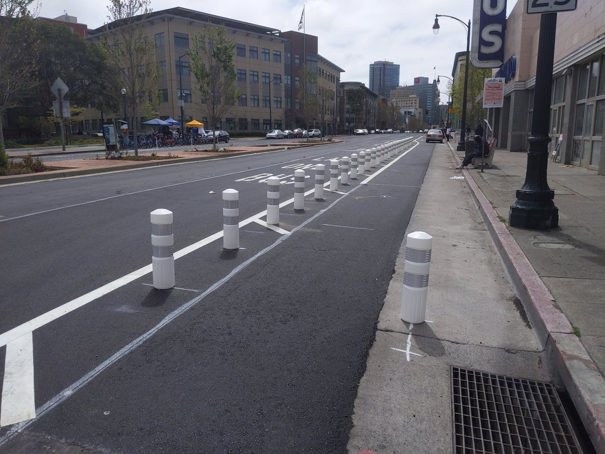 New K71-protected bike lane in Oakland, San Pablo between W. Grand and 20th. Note the extra post narrowing the entrance, so drivers can't sneak in. The post-to-post width there is 6'10", under the magic 7' threshold.Also note the driver blocking the lane just past the posts. 