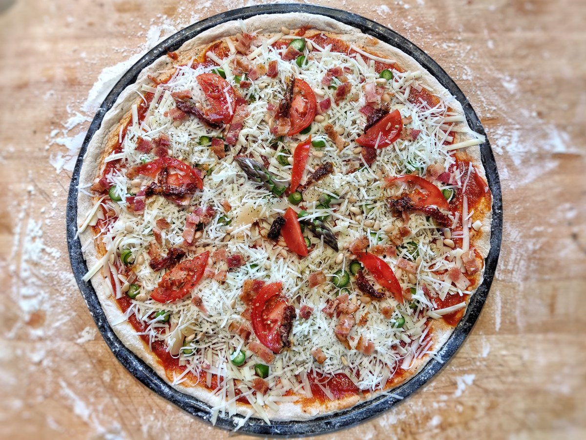 sed's tweet image. Pizza. #bacon #pear #freshtomatoes  #sundriedtomatoes #pinenuts #sourdough #romano #asparagus #mozzarella #oregano #basil #pizza #marinarasauce #staythefuckhome #flattenthecurve #beavercreekoregon