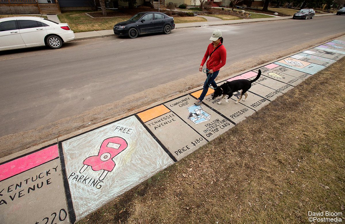A pedestrian walks along a sidewalk that has been turned into a chalk Monopoly board in Crestwood. #MidShiftPhotoWanderings #yeg