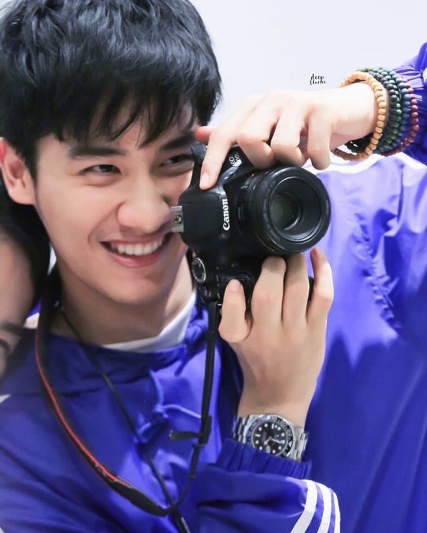 him smiling behind a camera
