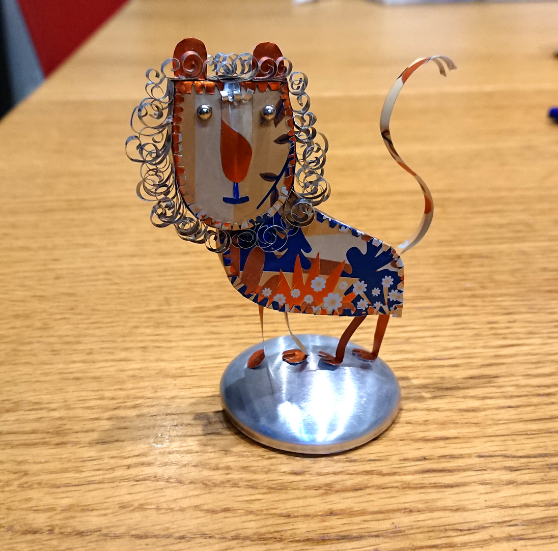 LittleJudyBrown's tweet photo. The bookshelf is getting a bit crowded now... My mum suggested a lion and here he is, the mane took AGES. It was a lidl craft cider can, and a very pretty one! #metalart #handmade #metalsculpture #upcycling #metallion #tincanzoo #canimal https://t.co/xSafUDjPAw
