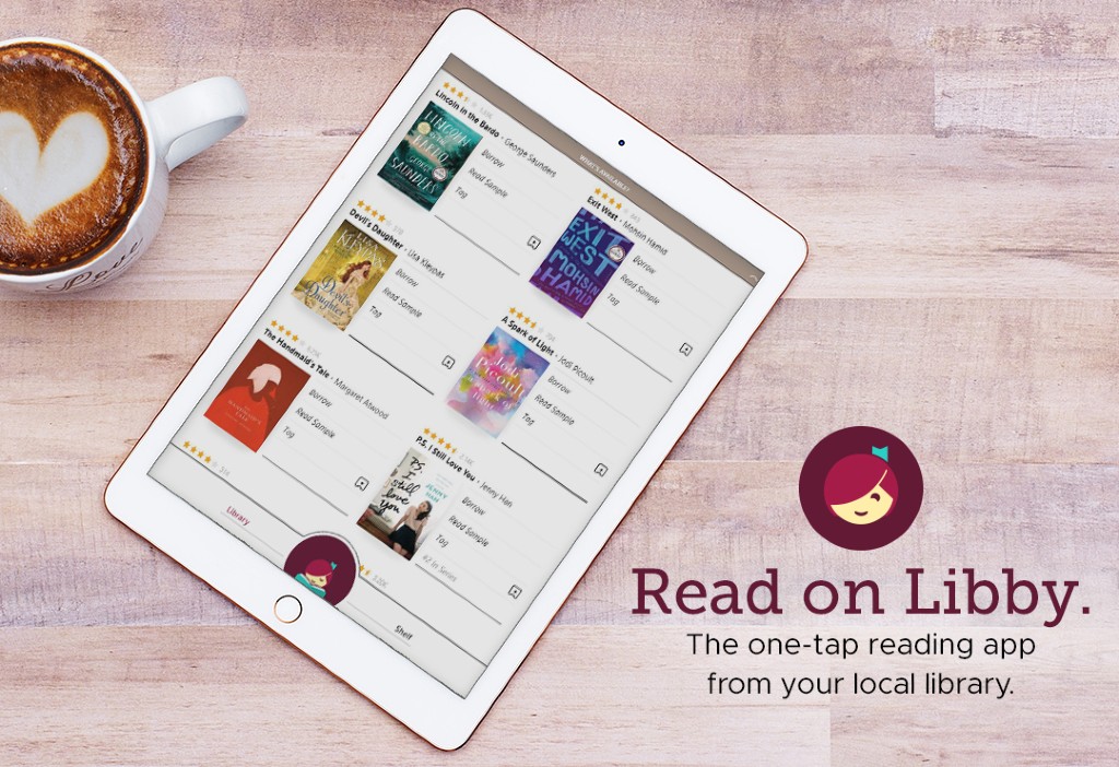 a photo of a tablet sitting on a desk next to a cup of coffee. The tablet is displaying the LIbby App.