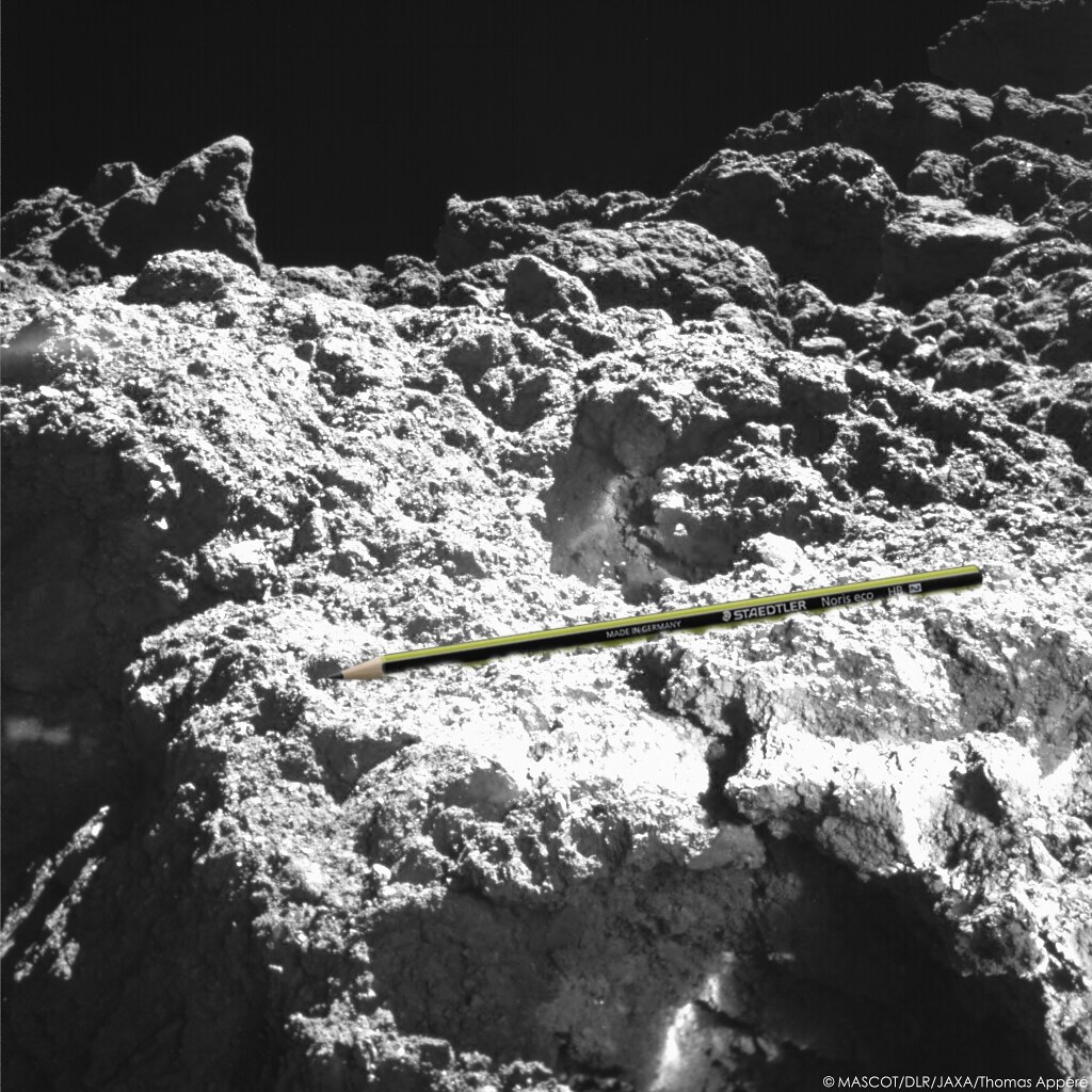 Lors de sa 2e journée sur Ryugu, MASCOT photographie de près son site d'atterrissage.2 types de rochers ont été observés sur Ryugu : certains brillants, lisses, aux arêtes vives et d'autres sombres, de forme irrégulière. MASCOT est en contact avec le 2e type de rocher.