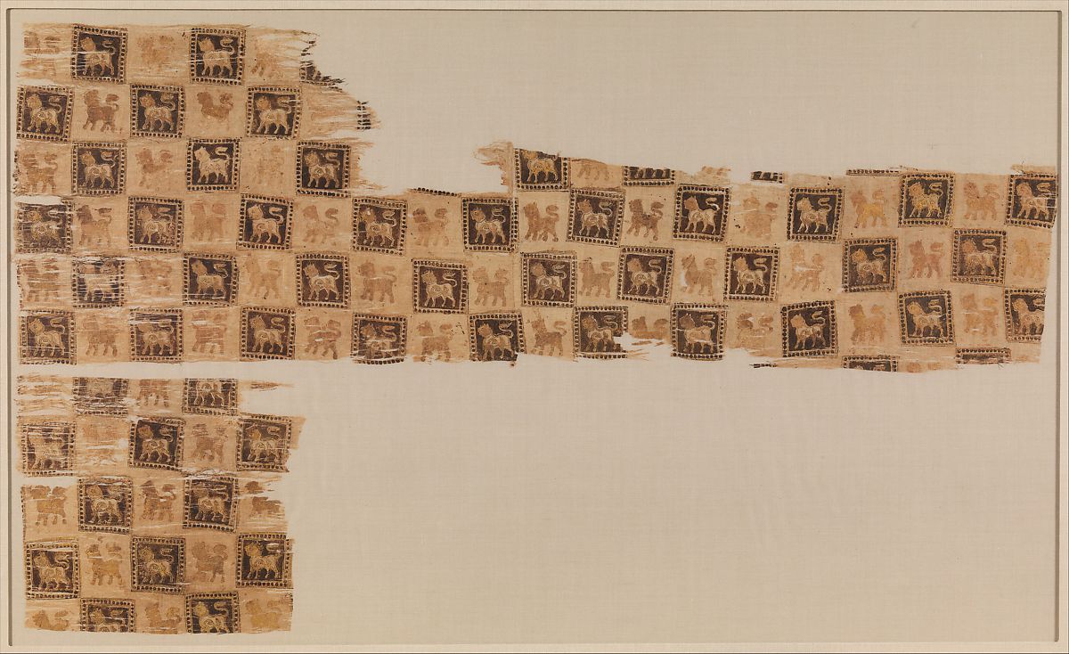 Textile fragment 10th–11th century. Ghaznavid. Most likely from Ghazni. The repeat checker-board pattern of this textile bears a design of a standing lion in profile, printed in gold against the brown squares and with reddish underdrawing against the light squares.
