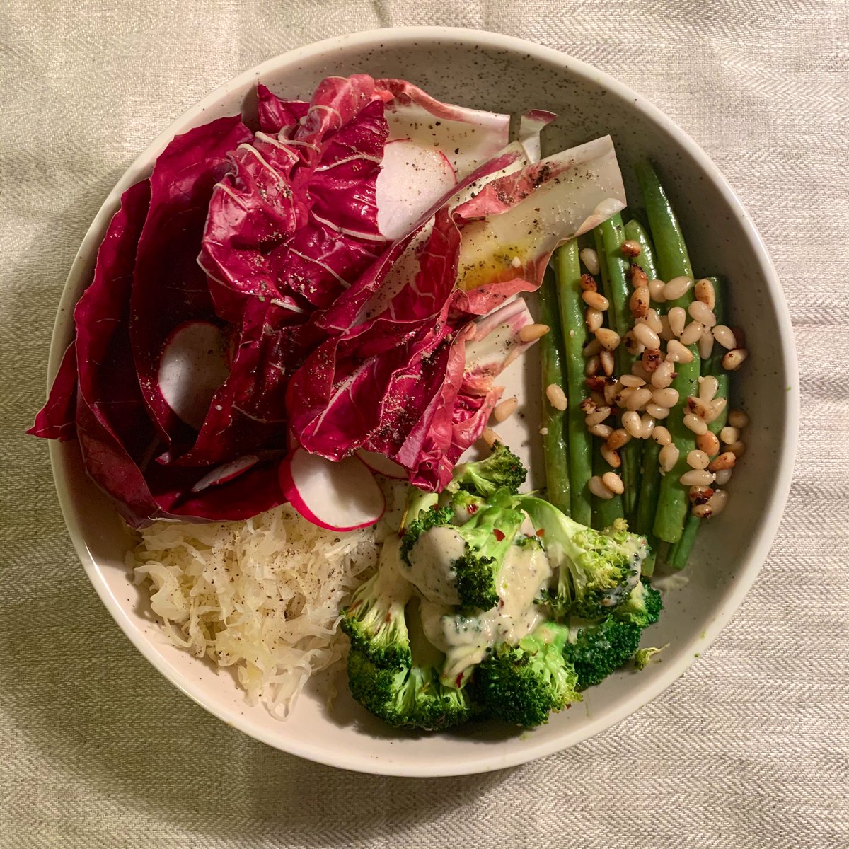 this is a 10pm dinner. i felt like green veggies so i made brocc with tahini chilli dressing and beans with pine nuts and garlic. and radicchio and radishes and kraut. thank u satan for your gifts