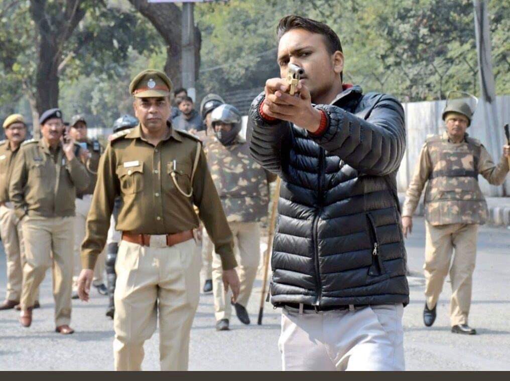 MianWaryyam's tweet photo. In the presence of police #RSS  jawan is firing on the students of #JamiaMilliaIslamia and in an other pic, the Muslim #Photoghaper was arrested just because she takes 
pictures by camera. This is #EmergingIndia #Democracy 

#Islamophobia_In_India #ShameOnModi #KashmirBleeds https://t.co/22JFsiylWy