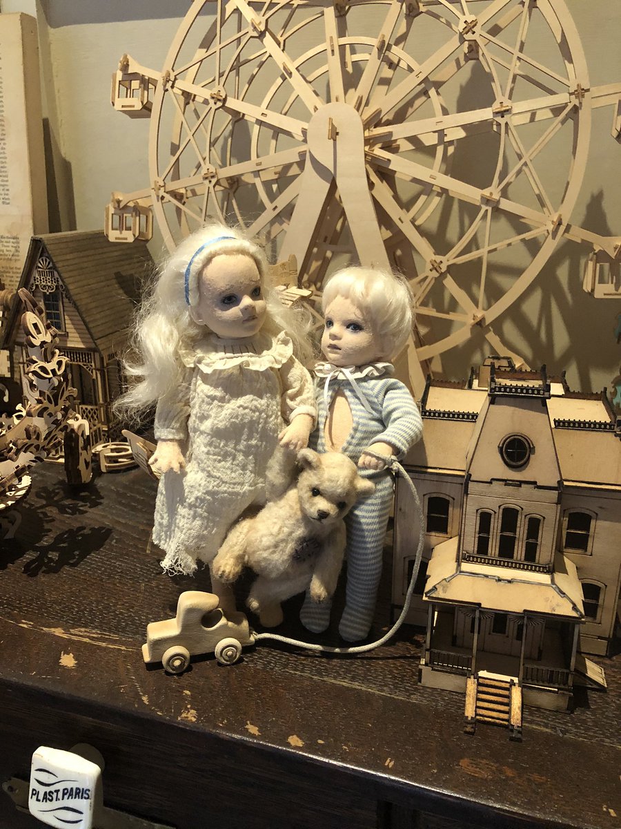 These dolls. Propped up on a scale model of the psycho house. On a medical cabinet.