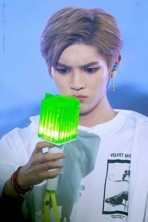 Taeyong the baby, confused by the Neobong (NCT lightstick)