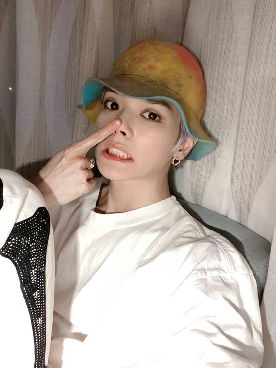 Taeyong the baby, wearing his colorful hat and booping his nose