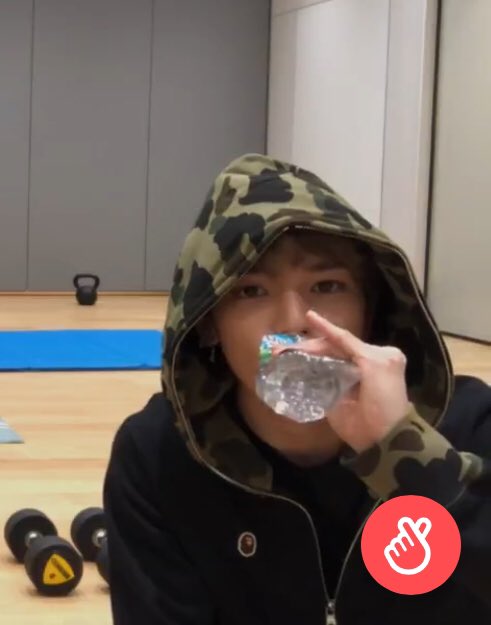 Taeyong the baby, sitting and sipping on his water bottle with his pinkie out