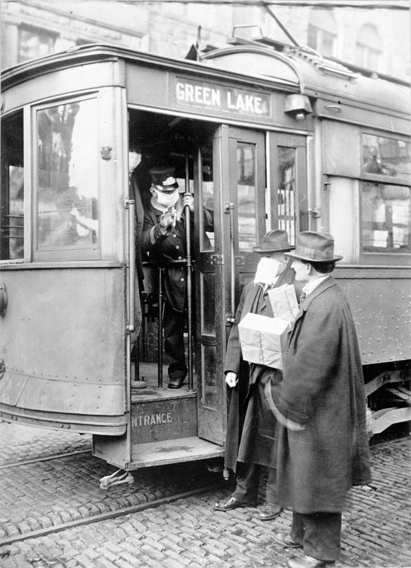 Street car conductor in Seattle not allowing passengers aboard without a mask. 1918.