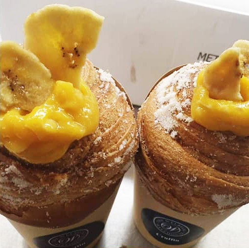 Enjoy the tropical taste of summer fruits with Welbeck Bakehouse's NEW tropical cruffin! Rolled in coconut caster sugar, filled with a tangy passion fruit curd and topped with banana chips! 

Now available in-store or add to your contactless collection order. 
Select days only!