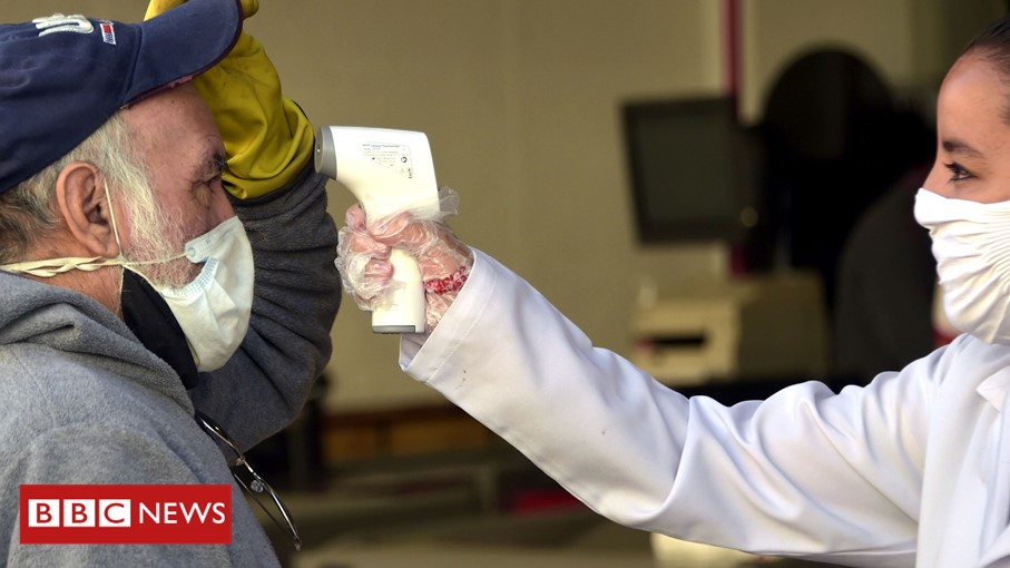 Healthcare worker takes a man's temperature