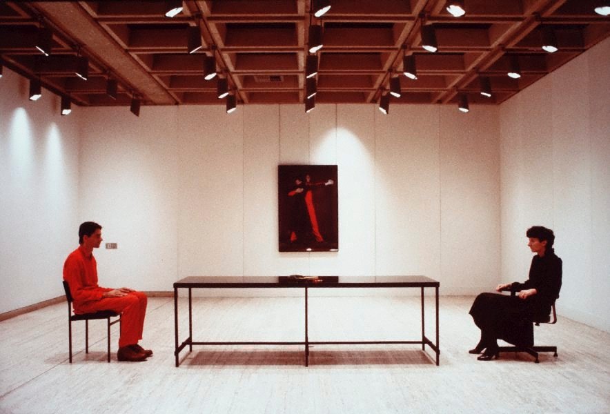 The art project, consists of Marina and Ulay sitting across from each other, for 7 hours straight, with and Aboriginal boomerang in the middle of the table. Guess the color scheme of this "art" project. Red and Black, just like Azarias dress