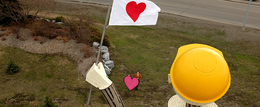 CityofPG's tweet photo. Bailey Grose, the creator of #HeartsofPG, visited Mr. PG today as he held up a new heart flag. Across the #cityofPG, BC, and worldwide, people have been taping paper hearts in windows to connect with others during the COVID-19 pandemic.
#heartsofPG #worldofhearts2020 https://t.co/tTQ2V0wtPT
